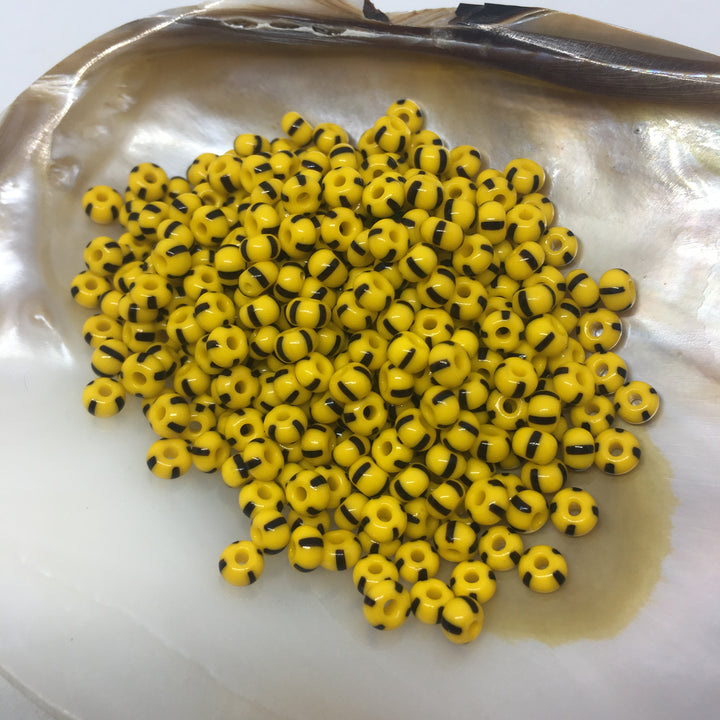 Stribede glasperler, seed beads, gule med sorte striber.